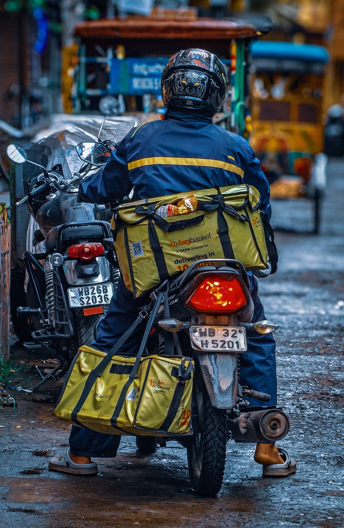 Insulated delivery bags strapped to a two-wheeler on an Indian street