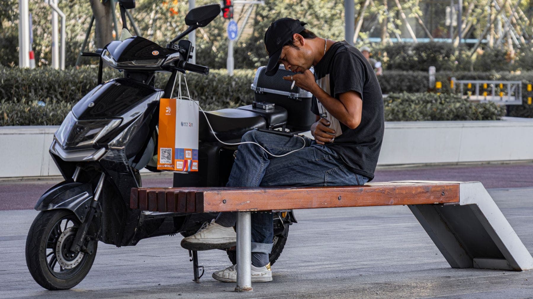 An electric scooter parked beside a bench in a city