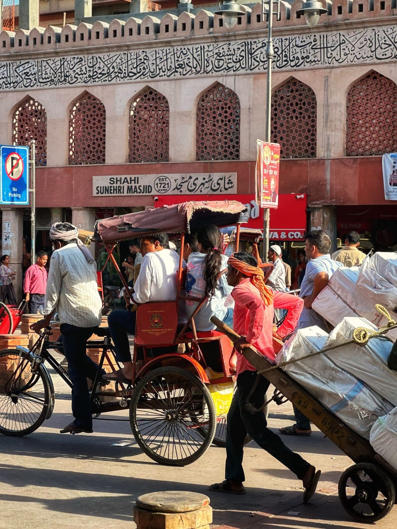 A busy Delhi street with cycle rickshaws and shopfronts