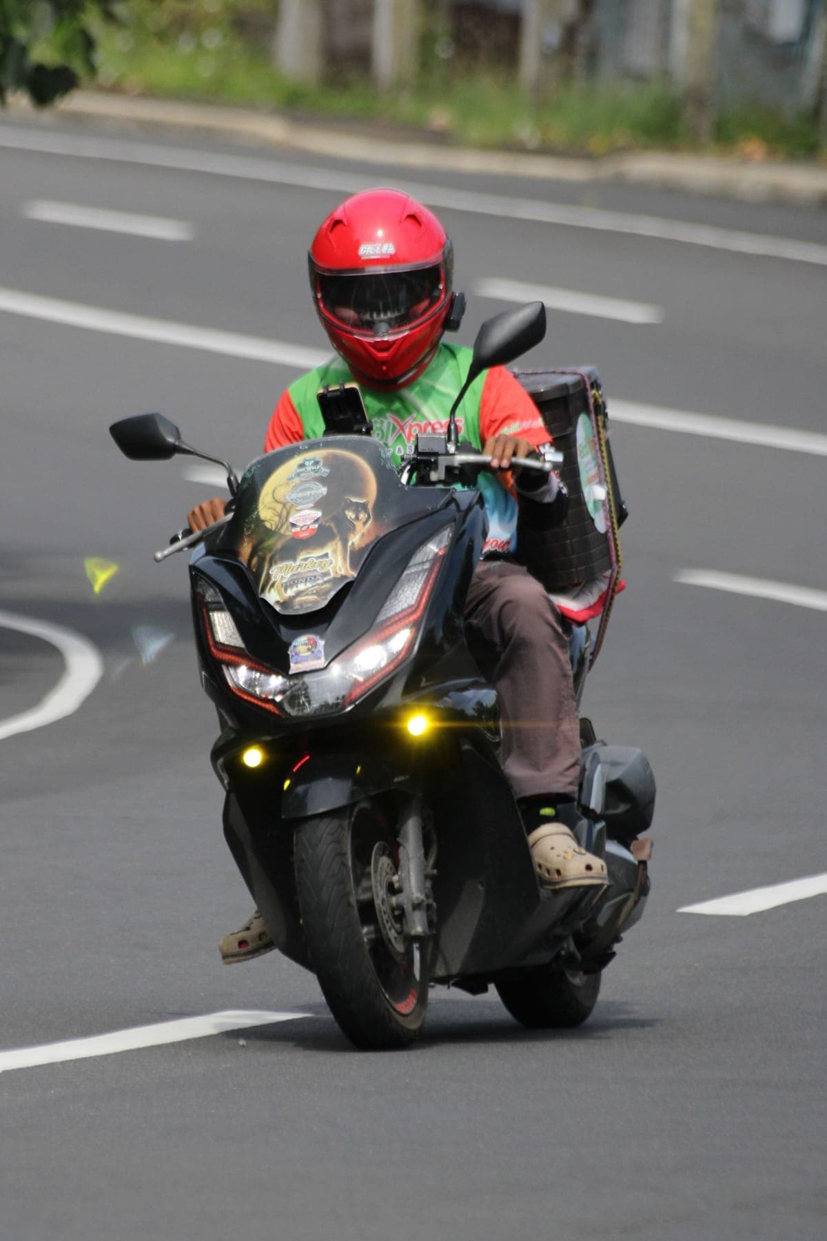 A courier riding through the city with a delivery box
