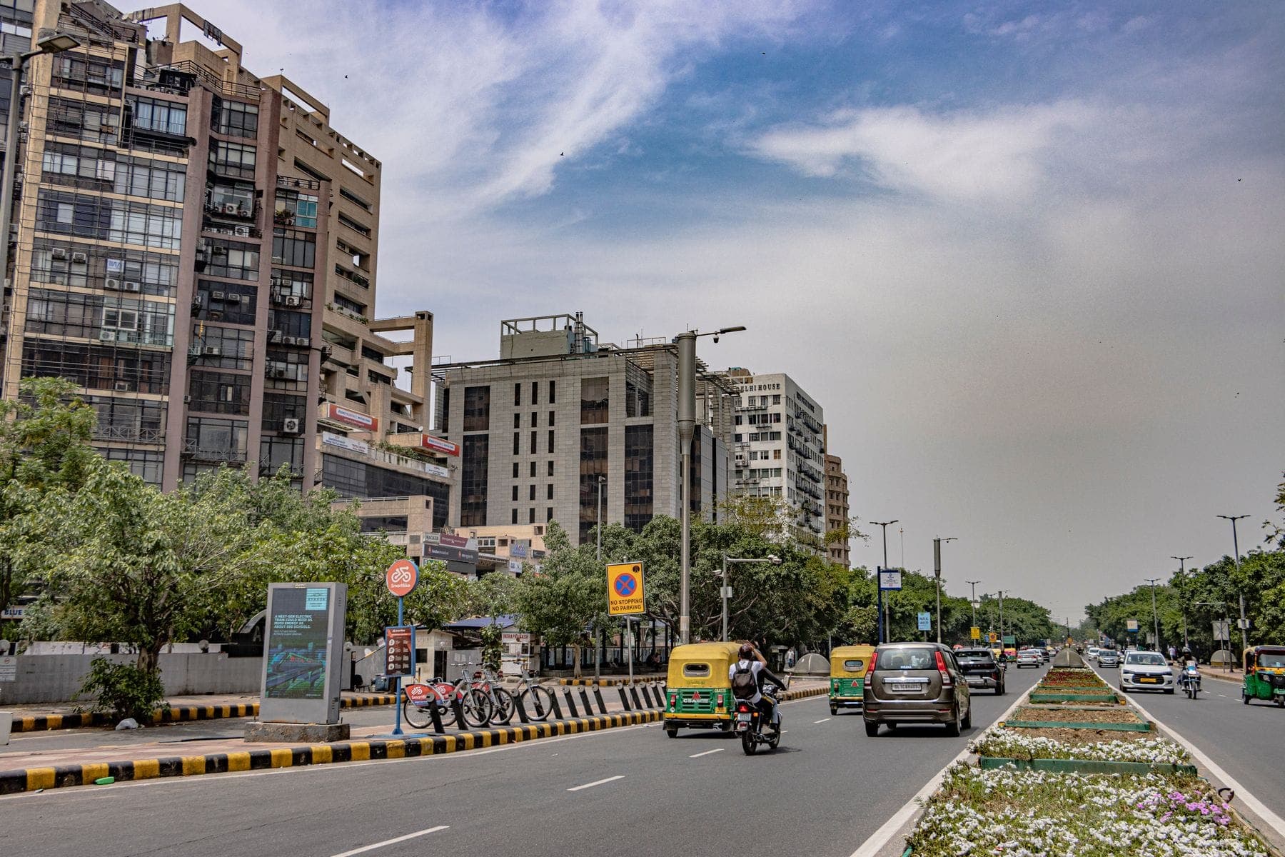 A Delhi road lined with modern buildings and greenery